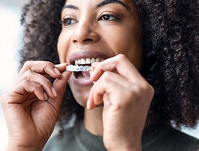 Woman placing Invisalign over upper arch
