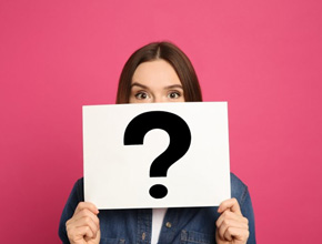 Woman holding a card with a question mark over her face