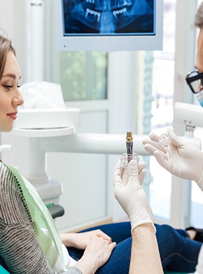 A dentist telling his patient how dental implants work