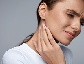 Frowning woman with jaw and neck pain