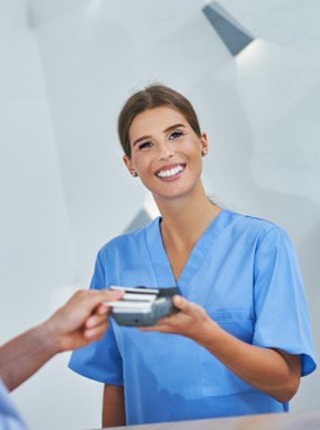 A patient paying the cost of a root canal in Manchester  