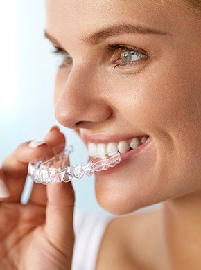 Woman placing Invisalign tray