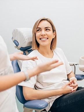 Woman smiling while talking to dentist at appointment