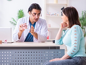 A denture dentist in Manchester speaking to a patient.