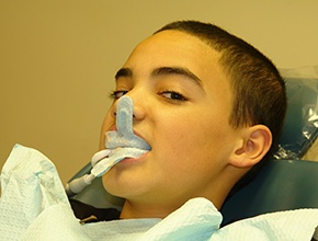 Child receiving fluoride treatment in a dental office