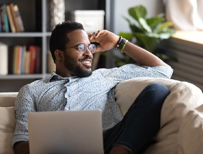 Man relaxing on couch with his laptop