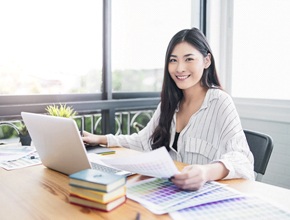 Woman with dental implants working at desk smiling