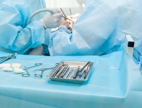 Dental instruments on bench while dental surgery is performed