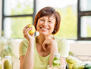 smiling woman holding an apple 