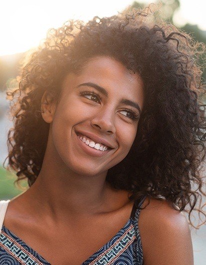 Young woman smiling outdoors on a sunny day