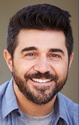 Bearded man in collared shirt smiling