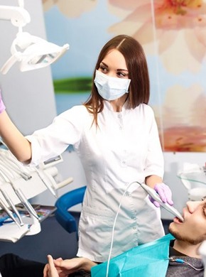 A dentist performing an oral exam.