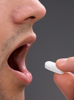 Closeup of patient taking oral sedative pill