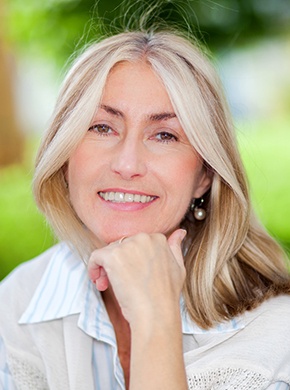 Older woman smiling with implant-retained dentures.