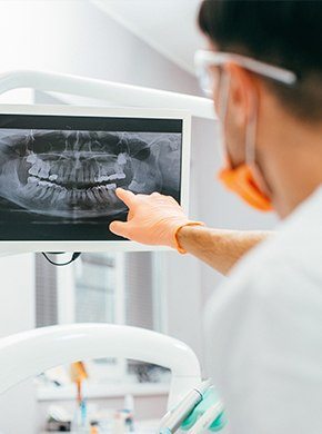 Dentist looking at dental x-rays on computer
