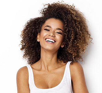 attractive woman curly hair smiling after teeth whitening in Manchester