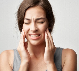 Woman with jaw pain, requires TMJ treatment in Manchester