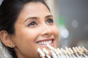 Smiling woman getting porcelain veneers in Manchester