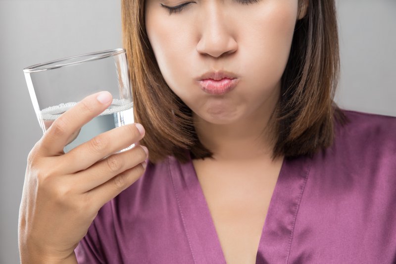 A woman rinsing her mouth with water