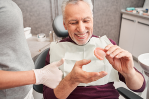a patient smiling and admiring their dentures