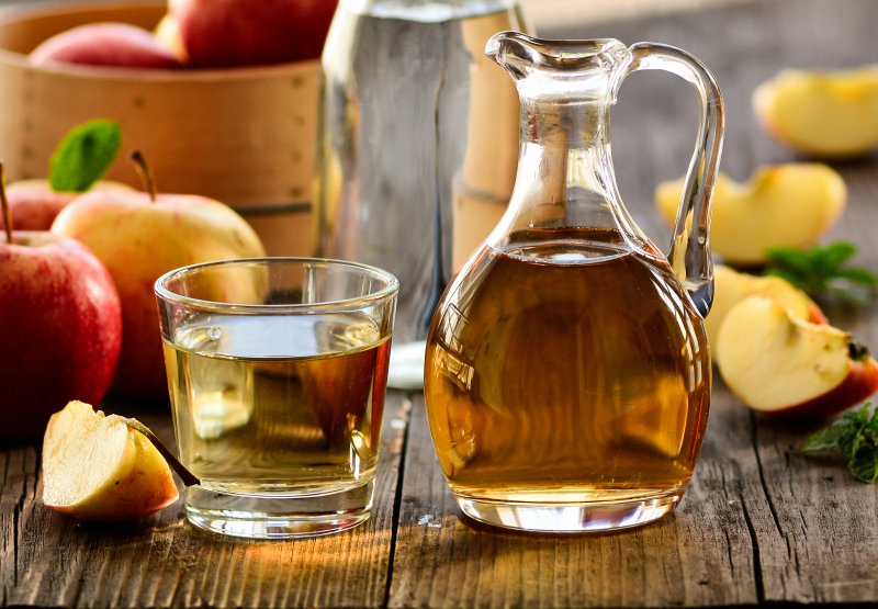 A glass and pitcher of apple cider vinegar