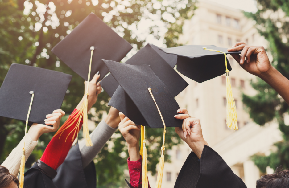 Graduation caps being held in the air.